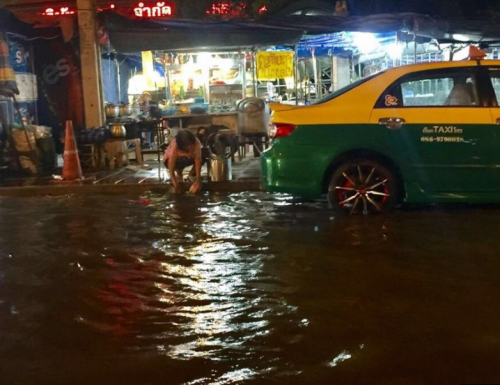 泰国餐馆大妈在地上积水中洗锅碗