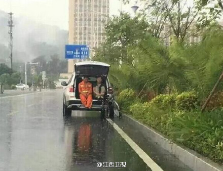 民警陪环卫工后备箱避雨 双腿蜷缩姿势获赞最美警察