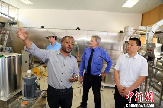 工作人員介紹中國—南非農業技術示范中心正在建設中的飼料加工車間。　宋方燦 攝
