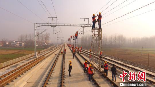 图为西成高铁现场工作人员正在架设接触网承导线。　刘仲兴 摄