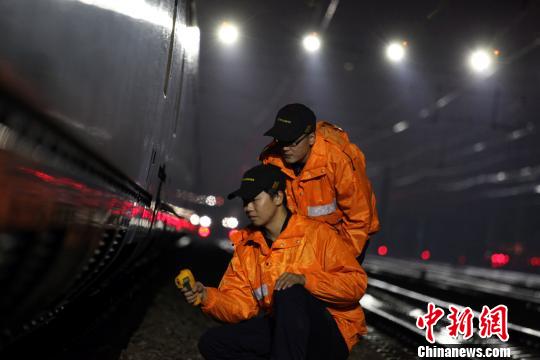 图为，“动车保姆”冒着严寒进行夜间检修保温工作。　许辉 摄