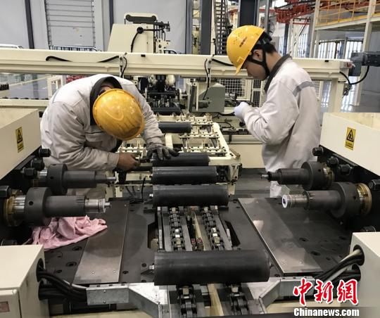 两位技术工人在泰富重装车间工作。　唐小晴 摄