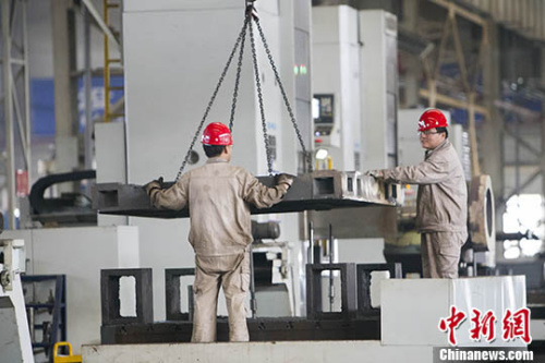 资料图：山西太重工人正在吊装机械配件。 中新社记者 张云 摄
