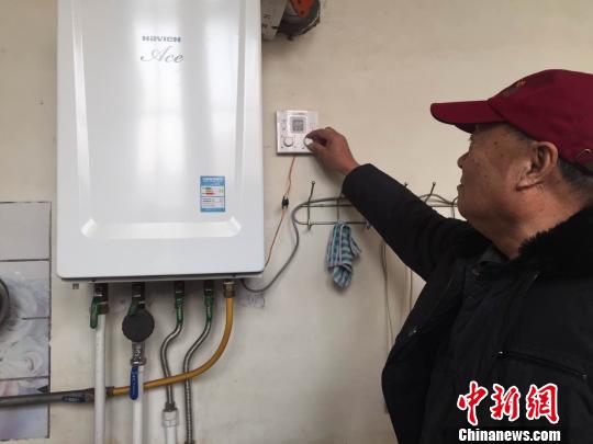村民调节壁挂炉温度 李茜 摄