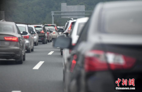 福建龙岩境内高速公路路面等候通行的车辆排起长龙。 中新社记者 张斌 摄
