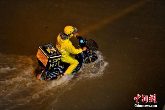 资料图为送外卖人员风雨无阻。中新社记者 王东明 摄