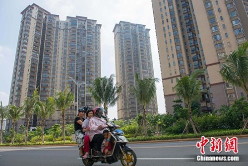 10月10日，市民在海口市区某地产项目前路过。 中新社记者 骆云飞 摄