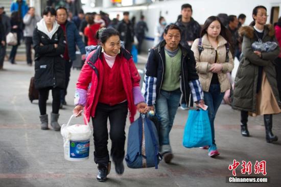 资料图：旅客带着行李在火车站乘坐火车出行。中新社记者 泱波 摄