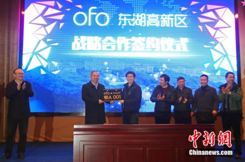 武汉市市委常委胡立山（左）授予ofo创始人兼CEO戴威编号为“鄂A001”的定制车牌