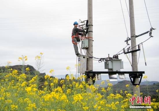 3月22日，春耕时节已至，重庆市綦江区三江街道龙桥村的油菜田里，几名国网重庆綦南供电公司电力工人正在对一处变压器进行春耕用电安全检查。当日，为保障重庆各地春季生产耕作期间安全用电，国网重庆市电力公司抽调电力工人深入到春耕生产一线，忙碌在田间地头认真仔细地加强线路设备隐患排查力度，检查排灌站、临时抽水用电线路及生产用电设备，了解农民需求，指导安全用电，帮助解决电力设备安装维修中的各种问题，保障春耕用电。据悉，重庆计划在两年内实现农村稳定可靠供电服务全覆盖。目前，该市中心村电网改造升级已经完成52%超过160多个村，为今年重庆农村春耕生产期间稳定安全用电奠定了坚强基础。周毅 摄