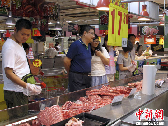 资料图：北京市市民在超市选购猪肉。中新社发 李慧思 摄