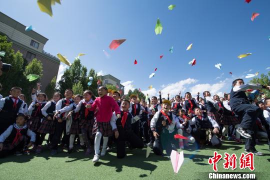 图为5月23日，西藏航空飞行部成员与孩子们一起放飞纸飞机“播种飞行梦”。　何蓬磊 摄