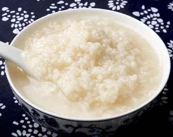 怎樣做甜酒釀?dòng)痔鹚侄?怎樣做甜酒釀?dòng)痔鹚侄嘞?></p><p>做甜酒釀是媽媽的拿手活。夏天吃媽媽做的甜酒釀，喝甜米酒（我們江西那邊土話(huà)叫水酒），是一家人在干農活勞累一天后最開(kāi)心的事情之一。父親在這一點(diǎn)上，也絲毫不吝嗇對我媽的贊賞，經(jīng)常一邊喝著(zhù)甜酒釀，一邊喳著(zhù)嘴說(shuō)“哎呀這甜酒釀是蠻甜，津甜津甜，有多少碗都能吃得掉”。我們兄弟幾個(gè)也是，一邊嘻嘻嗦嗦地喝著(zhù)甜酒釀，一邊互相監督勸阻，“一次不要喝那么多，留一點(diǎn)下次喝，還要做水酒呢”。</p><p>父親不抽煙、不打牌、不旅游，沒(méi)有其他嗜好，就愛(ài)在家喝點(diǎn)小酒。在江西農村，不管農忙農閑，喜歡喝點(diǎn)酒的人很多，男女老少很多都會(huì )喝一點(diǎn)。在我家鄉，那時(shí)候比較流行的是散裝零賣(mài)的冬酒、燒酒和自家做的水酒，夏天也有很多人喝啤酒。我父親喜歡喝酒，但是比較節省，不舍得花錢(qián)買(mǎi)酒喝，于是我媽自己動(dòng)手豐衣足食，承包了父親一年四季的米酒。俗話(huà)說(shuō)，有樣學(xué)樣，我們兄弟幾個(gè)從小也就跟著(zhù)父親也喝一點(diǎn)水酒。而我呢，最喜歡的是喝夏天的甜酒釀和甜水酒，冬天做的水酒（吊樓酒）度數高，沒(méi)有夏天的水酒那么甜。</p><p>媽媽做水酒的時(shí)候，很多時(shí)候都是我在旁邊幫忙燒火蒸糯米飯，因此我基本知道釀酒的全過(guò)程，只是我從來(lái)沒(méi)自己動(dòng)手嘗試過(guò)。我只負責在廚房燒火蒸糯米飯，搬抬東西需要兩個(gè)人的時(shí)候幫忙搭把手。燒火煮糯米飯的好處是當糯米煮成噴香的糯米飯后，可以第一個(gè)吃到媽媽手捏的糯米飯團。在我現在看來(lái)，以當時(shí)饑腸轆轆的時(shí)候吃上個(gè)糯米飯團，那噴香的滋味絲毫不比今天的炸雞腿遜色。</p><p>在我們家，做甜酒釀只是釀酒過(guò)程中的副產(chǎn)品，不是專(zhuān)為甜酒釀而做的。但是論吃，還是甜酒釀最好吃，并且很有營(yíng)養。在農村，甜酒釀都可以算作是一種營(yíng)養補品，富含蛋白質(zhì)、維生素和礦物質(zhì)，還可以用來(lái)促進(jìn)產(chǎn)婦乳汁分泌。當然，那時(shí)候我們都只是把它當成解渴解饞的醇甜飲品罷了。</p><p>小時(shí)候，每逢家里酒缸里的酒快見(jiàn)底的時(shí)候，媽媽就要開(kāi)始做下一缸的水酒。做水酒時(shí)，先用干凈水浸泡糯米6-8個(gè)小時(shí)，等糯米浸松脆后，洗洗再放進(jìn)蒸飯的圓木桶里，架在柴火灶上的大鐵鍋里蒸。等糯米蒸出糯米飯的香味來(lái)后，就把糯米取出來(lái)，放在竹制的盛物裝置里。給我們在家的幾個(gè)捏完糯米飯團后，拌散拌勻糯米飯，再往上澆干凈的涼開(kāi)水使之冷卻。糯米飯冷卻后，媽媽把從集市上買(mǎi)來(lái)的圓圓的酒曲餅，按適量的比例，放入糯米飯中攪拌均勻，然后就把糯米倒入土陶酒缸內，壓實(shí)，然后在用鍋鏟的圓木柄在糯米飯中間插個(gè)深洞。完了后就用一層棉麻紗布蓋在酒缸上面，用麻繩捆扎好，然后再用一層完好的塑料雨紙蓋在上面，捆扎密封。最后用一塊木質(zhì)圓形鍋蓋壓在上面，再放一塊石頭壓住。</p><p>夏天二三十度的室溫，正合適糯米中的淀粉發(fā)酵，做成甜酒釀的話(huà)大概三四天就夠了。做甜酒釀的時(shí)間火候，一般都是我媽親自把握。在糯米發(fā)酵時(shí)間差不多的時(shí)候，一邊觀(guān)察進(jìn)展，一邊當試吃官，當她宣布制酒成功，甜酒釀可以吃的時(shí)候，我們家幾個(gè)都迫不及待的溜進(jìn)房間，你一勺我一碗地舀起來(lái)喝個(gè)痛快。</p><p>雖然家里我媽會(huì )做甜酒釀，但能喝到甜酒釀的機會(huì )其實(shí)并不多。因為糯米發(fā)酵與氣溫的關(guān)系，甜酒釀好像只是在夏秋兩季天熱的時(shí)候適宜做，一年做個(gè)兩次就差不多了。甜酒釀做出來(lái)之后，也不是一直都是甜的，等發(fā)酵時(shí)間久了，酒釀會(huì )越來(lái)越稀薄，變成白白的一層覆蓋在水酒上，每次去舀水酒都要用酒勺蕩開(kāi)那一層薄薄的酒糟。</p><p>說(shuō)起喝水酒，那是我父親年輕時(shí)的一個(gè)愛(ài)好。父親曾經(jīng)說(shuō)過(guò)一個(gè)故事，以前在生產(chǎn)隊搞勞動(dòng)時(shí)，大家集體吃伙食，飯菜較差，沒(méi)什么油水，大家出工干重活都沒(méi)什么力氣。有時(shí)候，大家為了自己給自己鼓勁，就喊喊口號，什么加油干啊，干完回去吃飯有花生米！有水酒喝！大家就靠這么過(guò)過(guò)嘴癮，也能調動(dòng)積極性，喚發(fā)身體的能量。</p><p>我記得父親年輕的時(shí)候，周末在家吃飯，幾乎一天三頓每頓都要喝上一碗水酒，菜也不怎么講究，整點(diǎn)農家小炒肉，咸魚(yú)干，花生米，炒毛豆之類(lèi)的就可以了。但是父親也沒(méi)有酒癮，在學(xué)校上課的時(shí)候幾乎是不喝酒的，在外面也基本沒(méi)有花錢(qián)買(mǎi)喝酒的條件。</p><p>只是到了后來(lái)，父親身體漸漸差下去了，經(jīng)常胃潰瘍肚子疼，醫生建議少喝酒，后來(lái)就慢慢不怎么喝酒了。父親大概在50多歲的時(shí)候就戒了酒。父親戒酒之后，家里還繼續做了一兩年的水酒，在家里種地的兄弟有時(shí)也喝一點(diǎn)。直到后來(lái)，哥們陸續出去廣東打工了，家里沒(méi)有好喝酒的人了，母親做糯米酒的事情就放下不做了。</p><p>現在想想，雖然喝媽媽做甜酒釀的事兒已經(jīng)過(guò)去了二十幾年，但夏天喝甜酒釀的味道似乎還留存在舌尖、印記在腦海。后來(lái)到外面工作和生活，不管是應酬還是小聚，喝過(guò)各種各樣的酒，也喝過(guò)買(mǎi)來(lái)的甜酒釀，卻再也喝不出以前媽媽做的甜酒釀的味道了。那種唇齒留香、甜醇粘郁、嫩滑爽口的味道，隨著(zhù)時(shí)間和記憶的沉淀，成為一種與回憶少年、回憶家鄉、回憶親情相伴相依的特有香醇味道。</p>            </div>
          </div>
          <div   id=