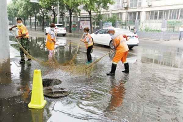 外面下着大雨,环卫工人清扫马路-暴雨后环卫工人紧急清扫泥沙
